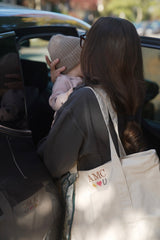 Custom embroidered natural tote with AMC initials and sun, heart and horseshoe icons